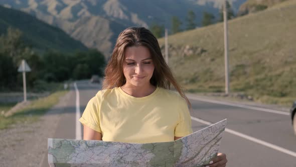 Portrait. Beautiful Female Tourist with a Map in His Hands Travels Walking on the Highway with a