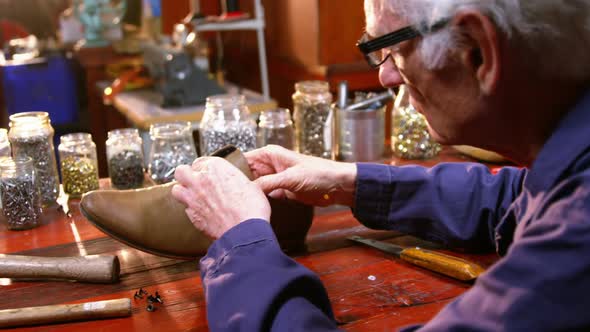 Shoemaker examining a shoe