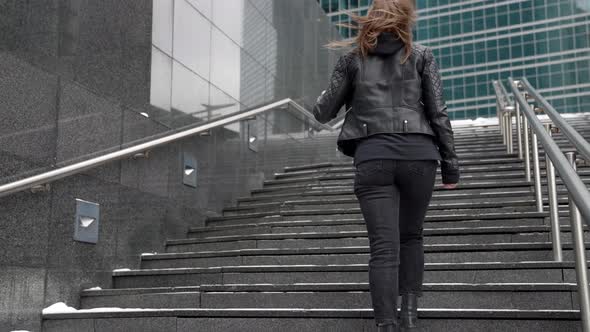 Female City Dweller is Walking in Downtown at Winter Day Woman is Going Up Over Stair