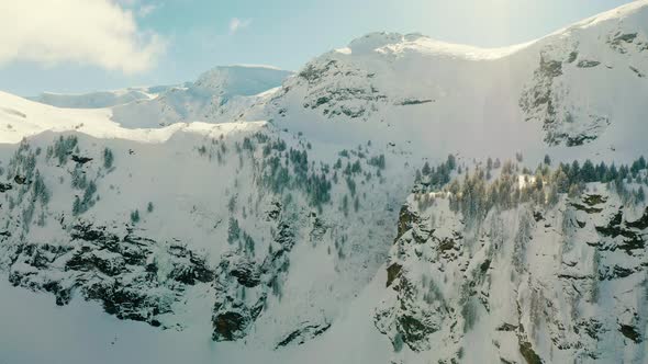 Flying Up near Snowy Mountain Peaks