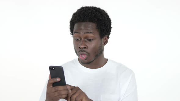 African Man Excited for Success While Using Smartphone White Background