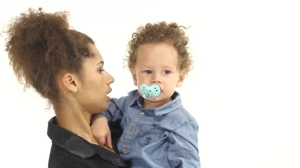 African American Mother Is Shaking a Small Child in Her Arms. White Background