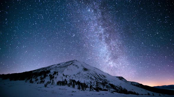 Twinkling milky way above the snowy peaks of the Carpathian Mountains. Cinemagraph.