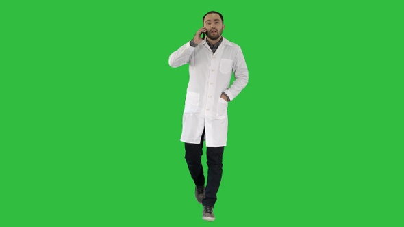 Male doctor walking and talking on the phone on a Green