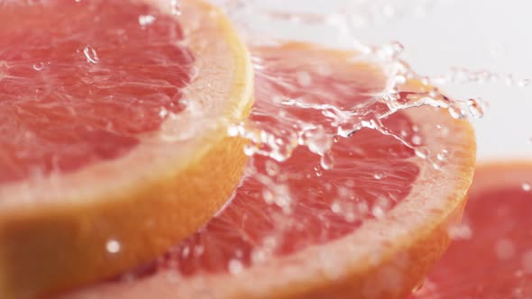 Water splash on pink grapefruit. Slow Motion.