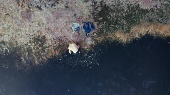 AERIAL TOP DOWN - An ice bather finishes his practice and exits the water