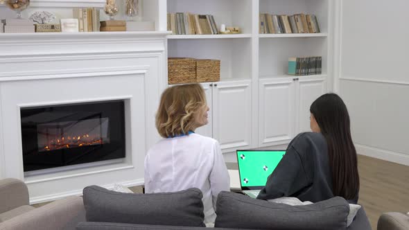 Female Doctor Explaining to Patient Medical Test Results on Laptop During Homecare Visit