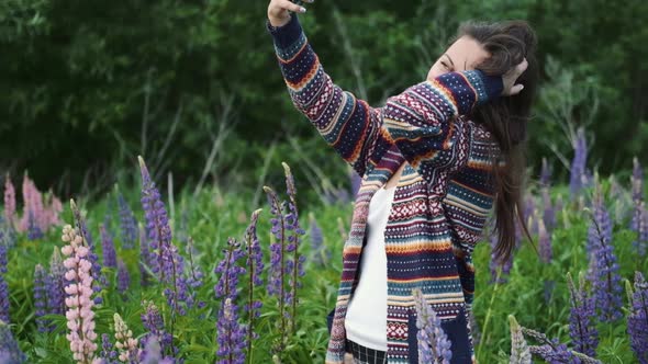 Happy Woman Enjoying the Outdoors Using Her Cell Phone.young Brunette Takes a Selfie on a Background