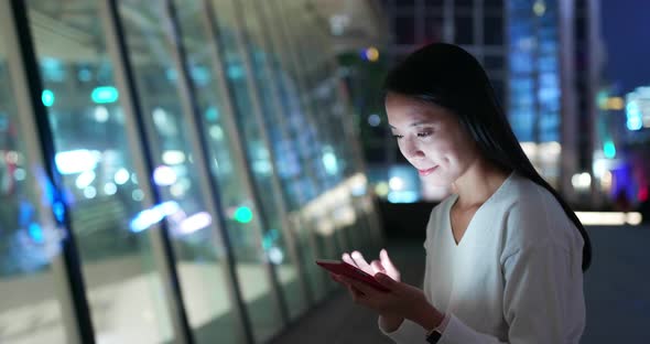 Woman use of mobile phone in city at night