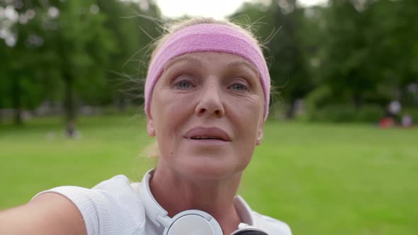 Pov Shot of Mature Woman in Sportswear Having Video Call Standing in Summer Park