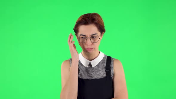 Portrait of Funny Girl in Round Glasses Is Thinking About Something. Green Screen