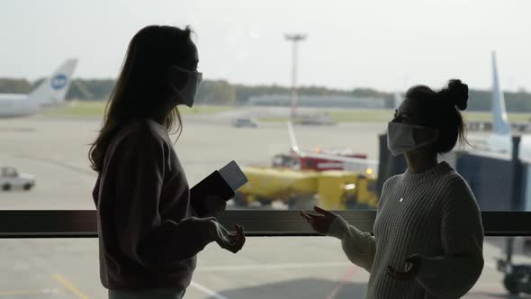 Two Women Tourists in Medical Mask Meet in Airport Terminal at Safe Distance Before Flight and Greet