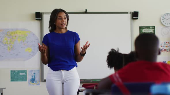 Portrait of mixed race female teacher standing in classroom conducting a lesson