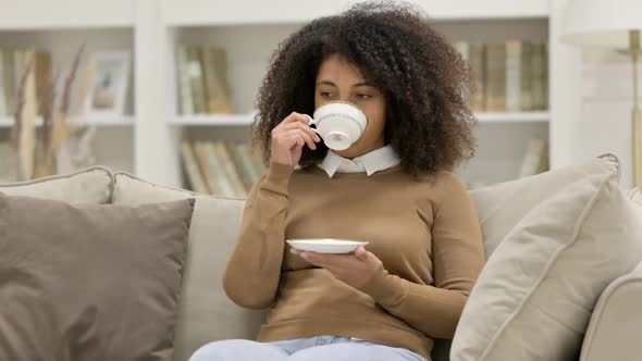 Young African Woman Drinking Tea on Sofa