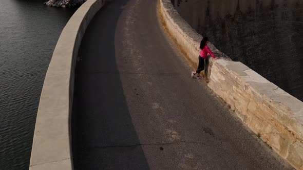 Aerial of a woman hiking across the Salmon Falls Dam in Southern Idaho