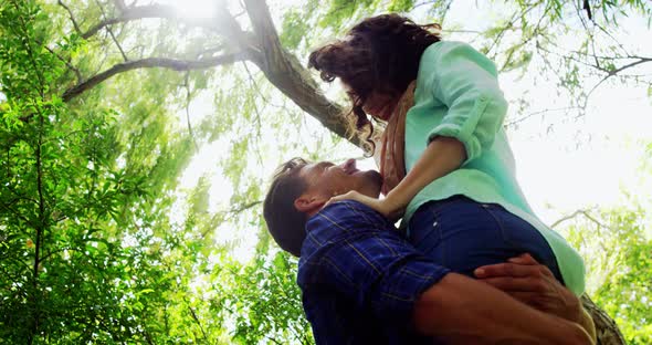 Romantic man lifting woman in park