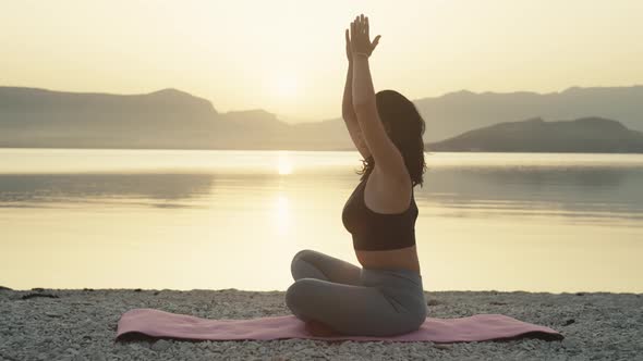 Girl Meditates at Sunrise By the Ocean