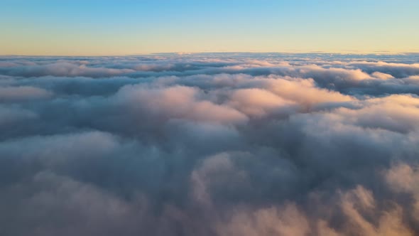 Aerial View From Above at High Altitude of Dense Puffy Cumulus Clouds Flying in Evening