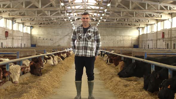 Happy farmer at meat fattening farm looking at camera.