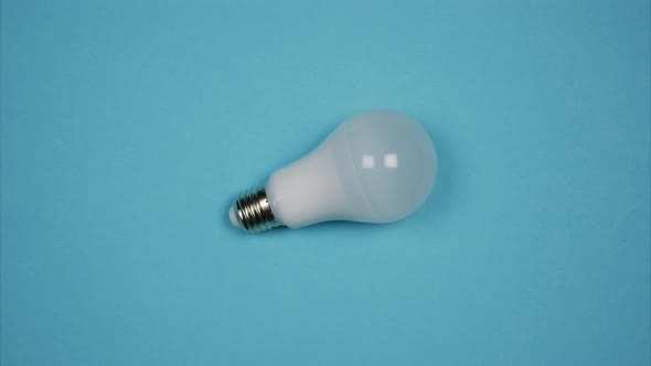 Illuminated Lamp, Energy Saving And Led Bulb Changing One Another Isolated On Blue Background