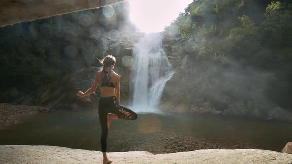 Girl Stands in Yoga Position Against River Sun Rays