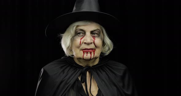 Old Witch Halloween Makeup. Elderly Woman Portrait with Blood on Her Face.