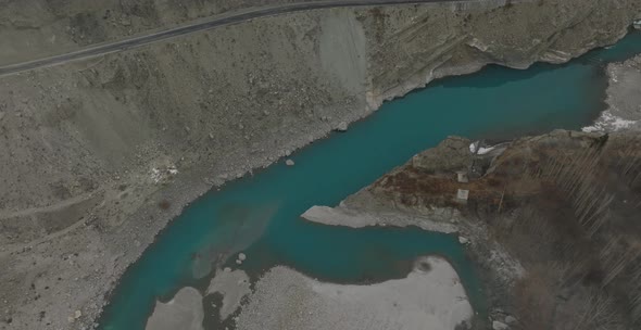 Aerial Over Calm Turquoise River Water In Hunza Valley Beside Road. Circle Dolly