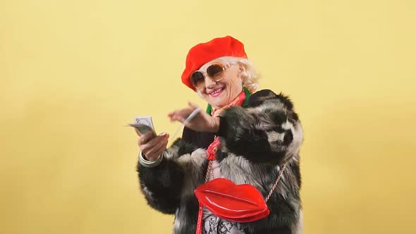 Happy Glamour Senior Old Lady Throwing Stack of Dollar Bills