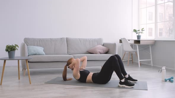 Lady Doing Abs Crunches Exercise Lying On Floor At Home