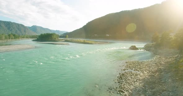 Low Altitude Flight Over Fresh Fast Mountain River with Rocks at Sunny Summer Morning.