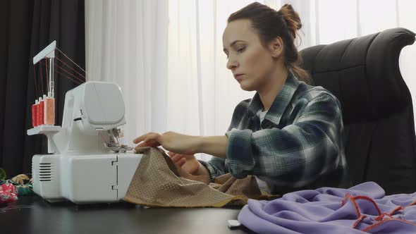 Woman fashion designer creating dress details from fabric in tailor workshop studio. Sewing concept