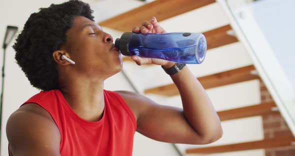 Fit african american man exercising at home and resting tired at home