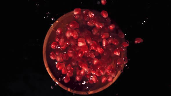 Super Slow Motion of the Grain of Ripe Pomegranate in a Wooden Plate