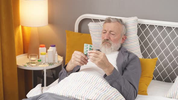 Sick Person Taking Pills Medicines While Lying on Bed