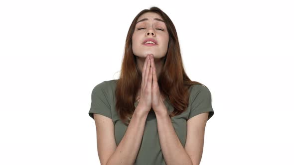 Portrait of Praying Woman with Beautiful Auburn Hair Looking Upward with Hope and Keeping Palms