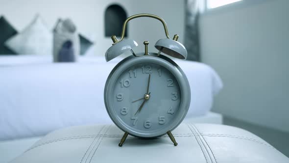 Closeup Vintage Alarm Clock on a Bed at Bedroom at Home in the Morning