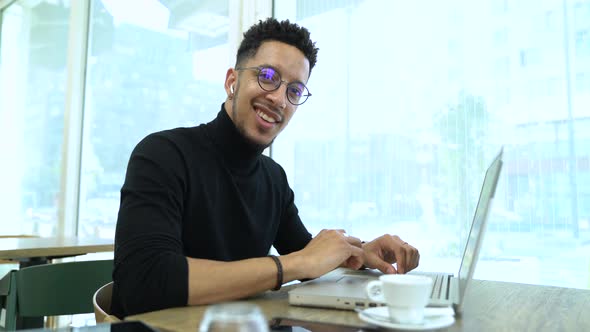 Businessman using laptop while listening music