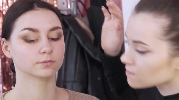 The Stylist Makeup Master Makes an Eye on the Evening Stylish Bright Makeup on a Young Girl Model in