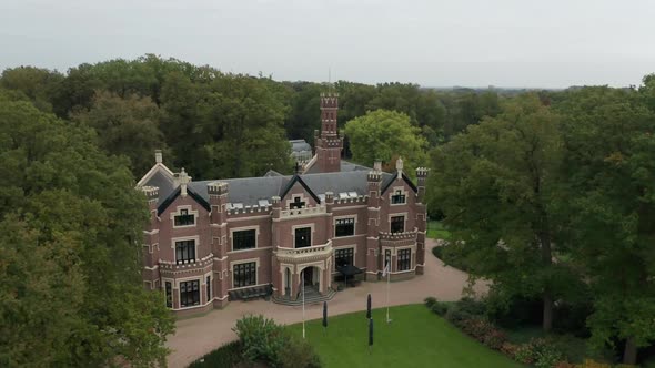 Aerial of person leaving Schaffelaar Castle, a beautiful mansion on a green estate