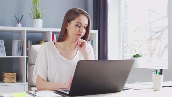 Young Woman Works at Home Office Using Computer.