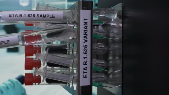 Eta B.1.525 Test Tube Samples Being Placed Into Rack. Vertical Video, Locked Off