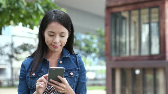 Woman looking at cellphone at outdoor park