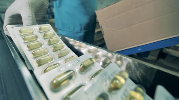 Pharmacologist Packing Blisters of Capsules Into a Box. Pharmacist Working, Pharmaceutical Industry