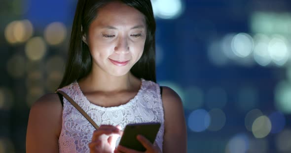 Woman using smart phone at night