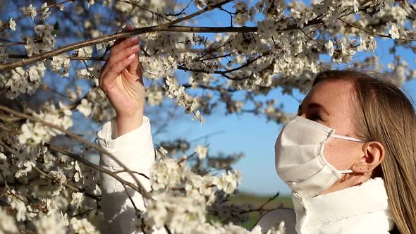 Girl in white jacket photographs white color in spring, using smartphone for photo