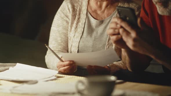 Elderly Couple Calculating Utility Payments and Joking