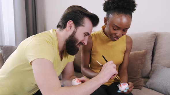 Black Woman and European Man Painting Easter Eggs Together