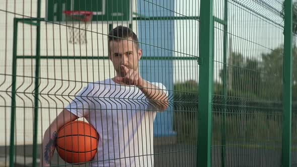 Basketball Player is Showing Index Finger to Camera on Open Sporty Court