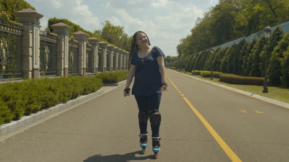 Joyful Female Rollerskating at Speed on Park Path