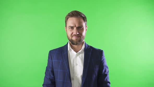 Handsome American Businessman Posing for Camera and Smiling on Green Background.